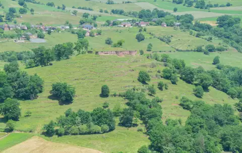 Vue aérienne des ruines du château de Beaucaire sur leur colline boisée, à Nauviale en Aveyron