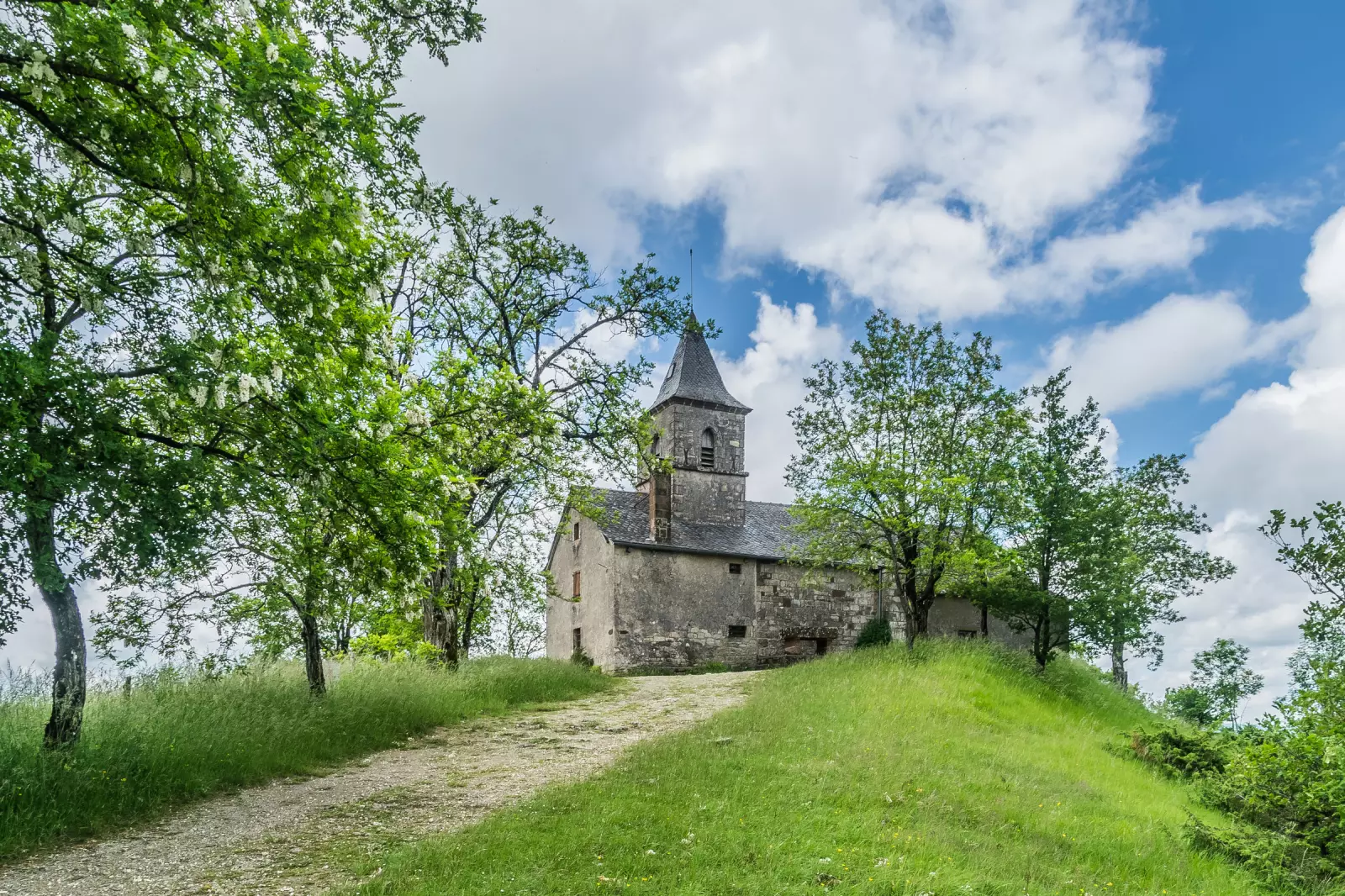 La chapelle romane de Saint-Jean-le-Froid sur son piton, à Mouret en Aveyron