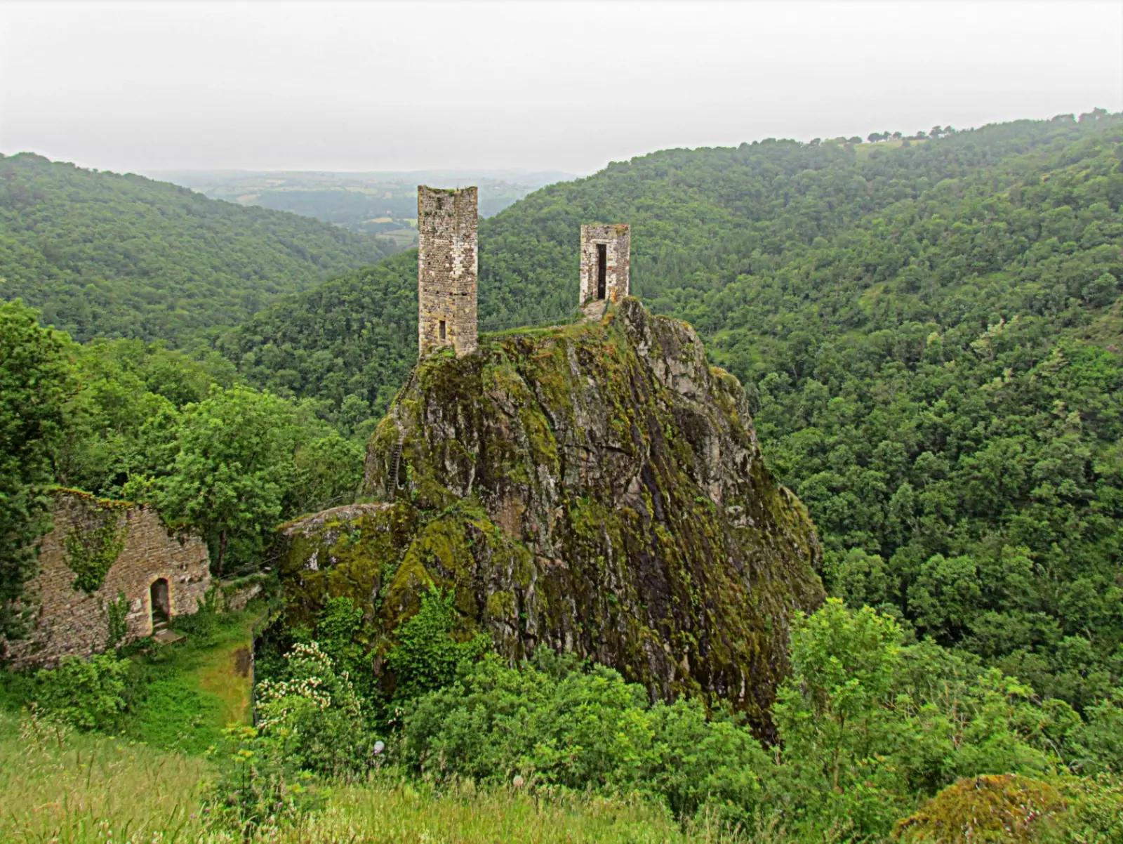 Les deux tours en ruine du château inférieur de Peyrusse-le-Roc, perchées sur un éperon rocheux au-dessus de la vallée, en Aveyron